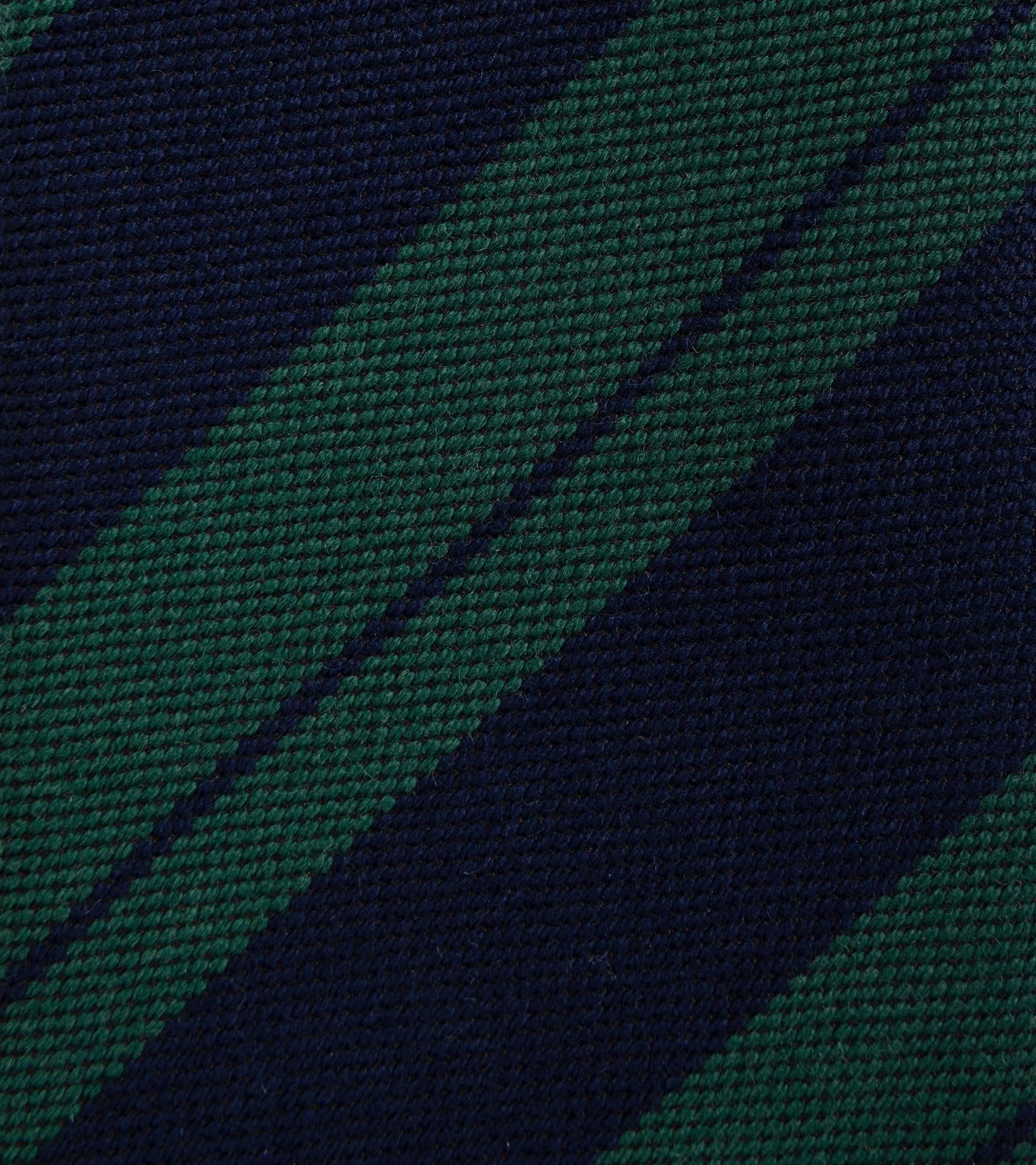 A close-up of a woven fabric with diagonal stripes in dark navy blue and forest green.