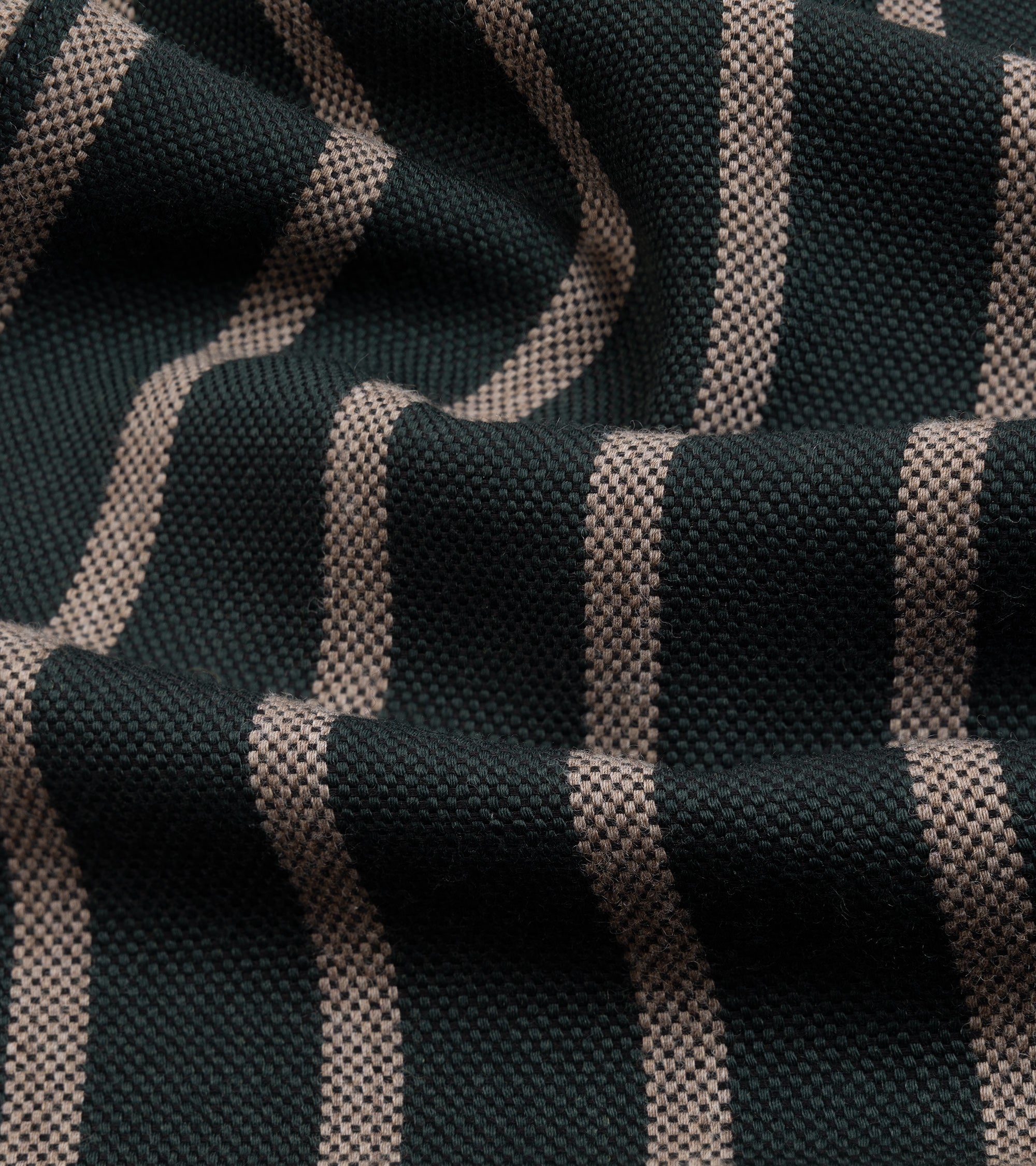 A close-up of woven fabric with dark green and beige vertical stripes, showing the texture and pattern details.